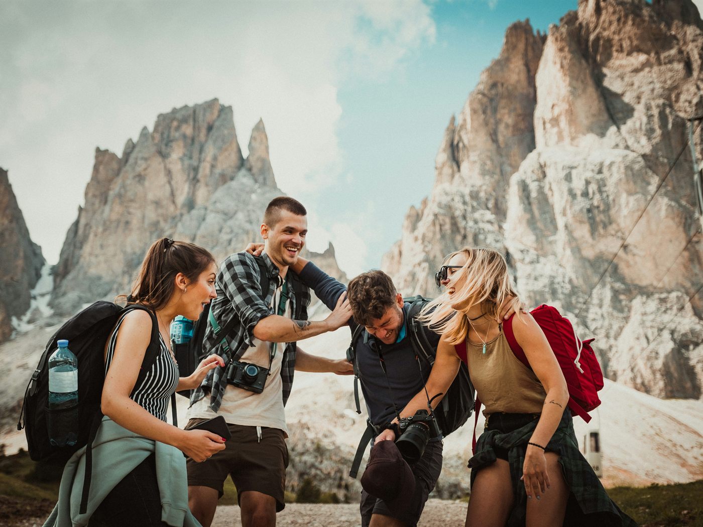 A group of hikers laughing together in front of mountain peaks